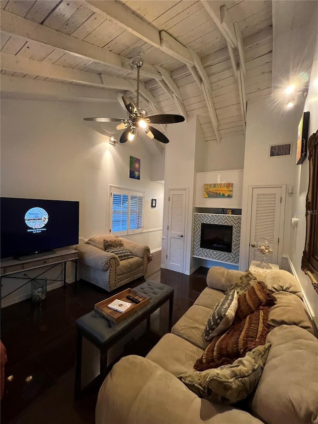 living area featuring wood ceiling, visible vents, a tiled fireplace, and wood finished floors