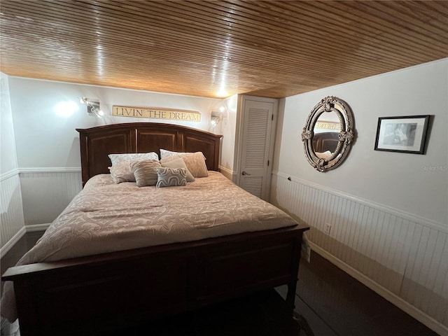 bedroom with wooden ceiling and wainscoting