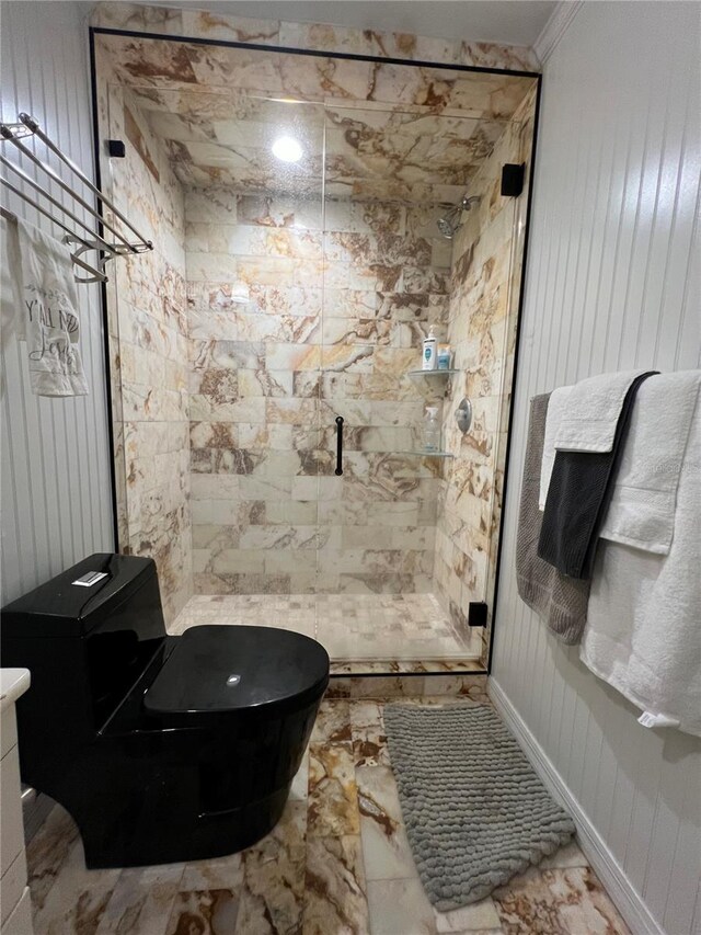 bathroom with a shower stall, toilet, and baseboards