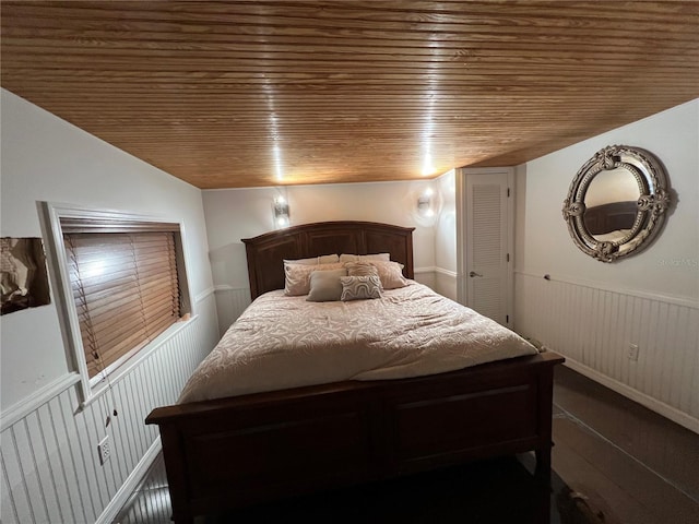 bedroom with wood ceiling and wainscoting