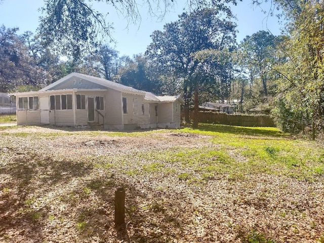 view of property exterior with entry steps and a sunroom