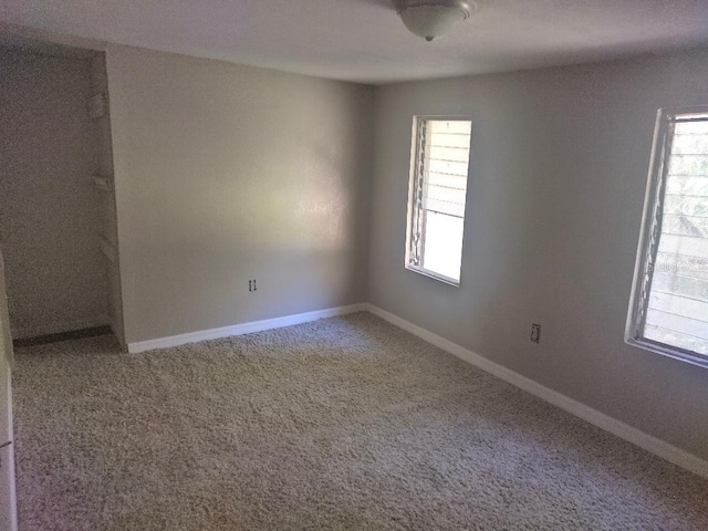 carpeted spare room with baseboards