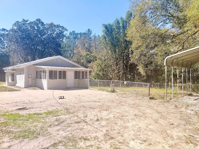 view of home's exterior featuring fence and a carport