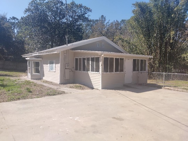 view of front facade featuring driveway and fence