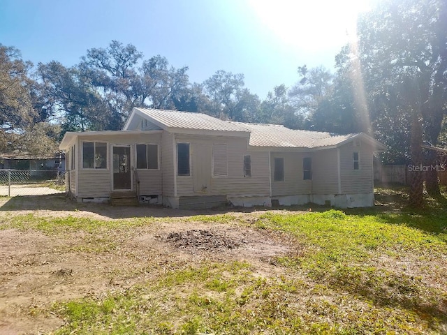 exterior space featuring entry steps, crawl space, fence, and metal roof