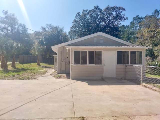 view of front of property featuring a patio area and fence