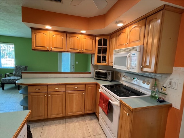 630 Yupon Ave, New Smyrna Beach, FL 32169 - kitchen with a peninsula, white appliances, a toaster, and brown cabinets