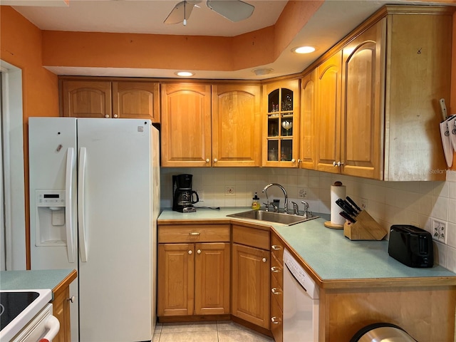 630 Yupon Ave, New Smyrna Beach, FL 32169 - kitchen with white appliances, decorative backsplash, brown cabinetry, and a sink