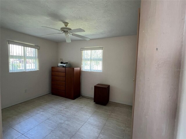 630 Yupon Ave, New Smyrna Beach, FL 32169 - unfurnished bedroom featuring a textured ceiling and a ceiling fan
