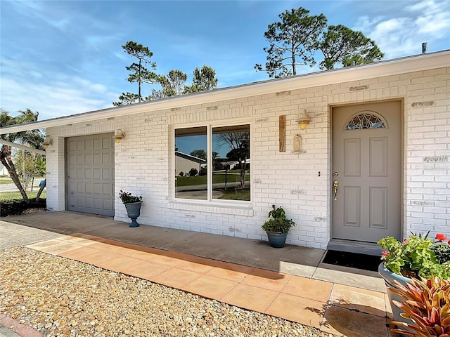 property entrance featuring an attached garage and concrete driveway