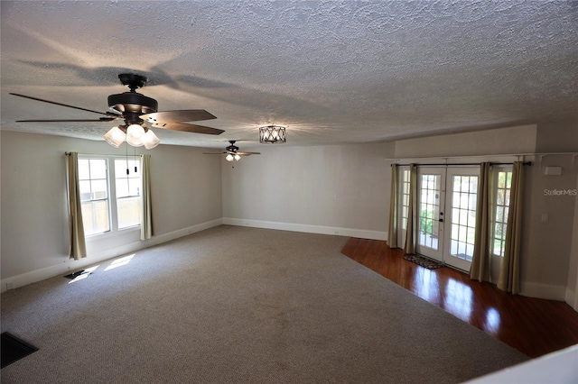 carpeted spare room with visible vents, baseboards, and a textured ceiling