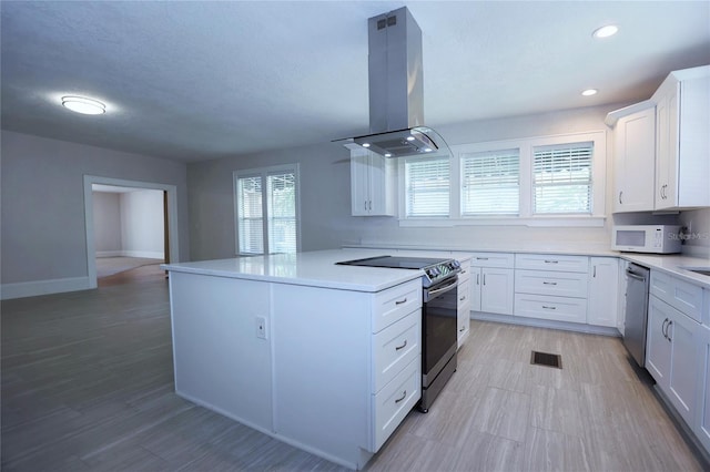 kitchen featuring visible vents, light countertops, island exhaust hood, stainless steel appliances, and white cabinetry