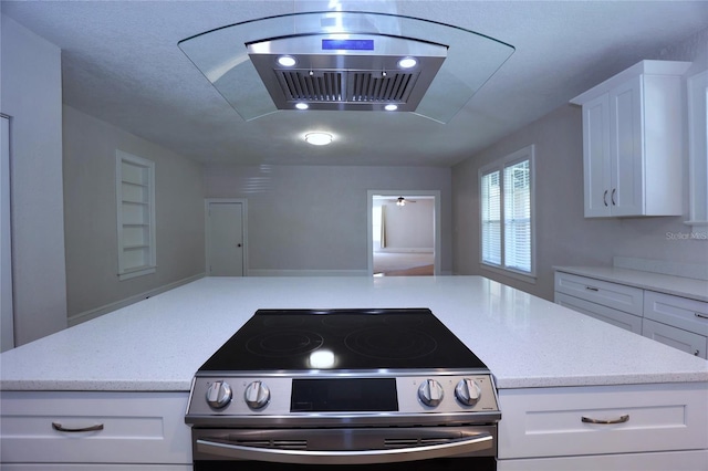 kitchen featuring light stone countertops, stainless steel range with electric stovetop, and white cabinetry