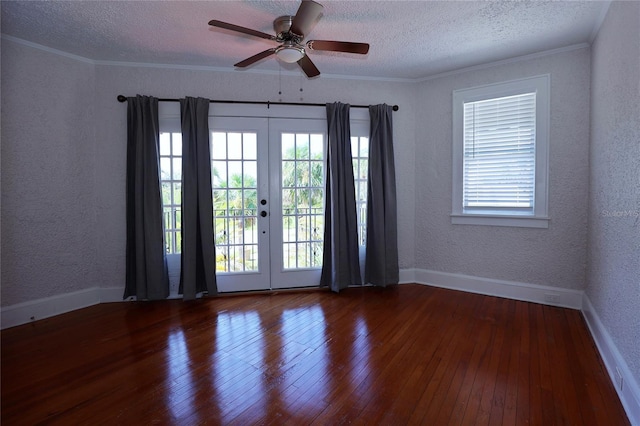 unfurnished room with hardwood / wood-style floors, plenty of natural light, ornamental molding, french doors, and a textured wall