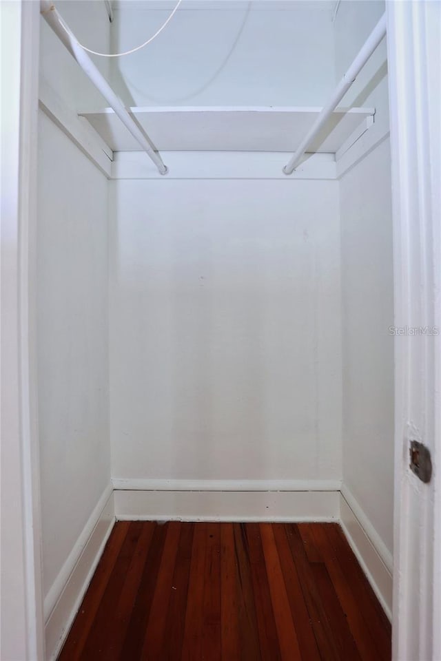 spacious closet with dark wood-style flooring