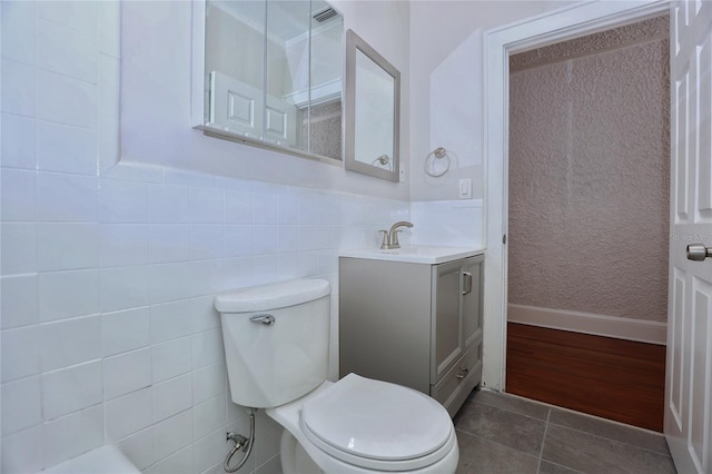 bathroom with vanity, visible vents, tile patterned flooring, tile walls, and toilet