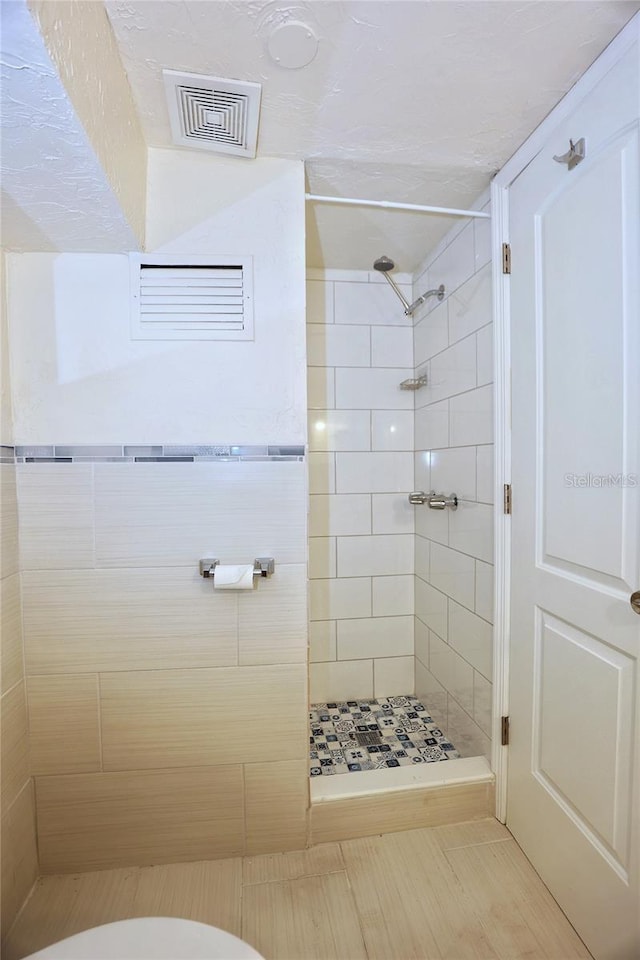 full bathroom featuring visible vents, a stall shower, and toilet