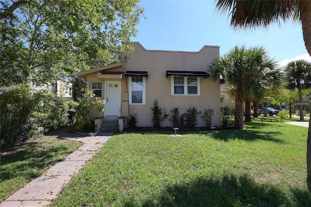 view of front of home featuring a front yard and stucco siding