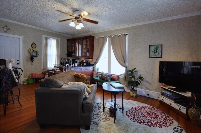 living room with ceiling fan, crown molding, wood finished floors, and a textured ceiling