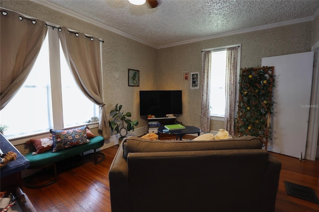 living area featuring visible vents, plenty of natural light, crown molding, and hardwood / wood-style flooring