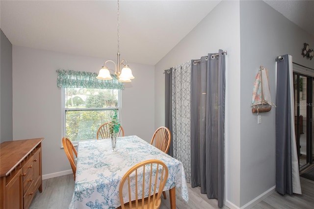 dining space with lofted ceiling, an inviting chandelier, light wood-type flooring, and baseboards