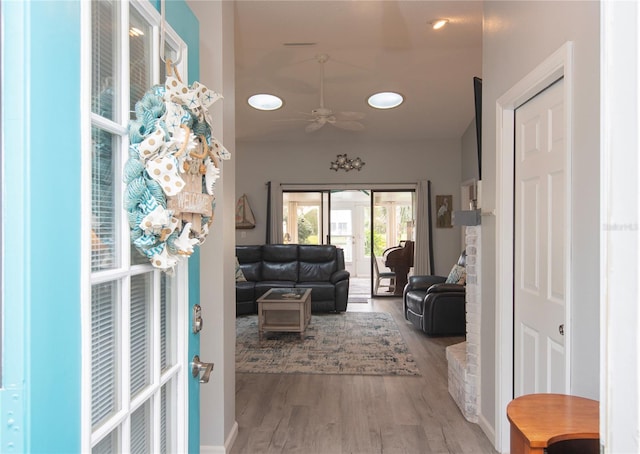 living room with a ceiling fan, lofted ceiling, and wood finished floors