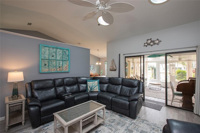 living area featuring lofted ceiling, visible vents, a ceiling fan, and wood finished floors