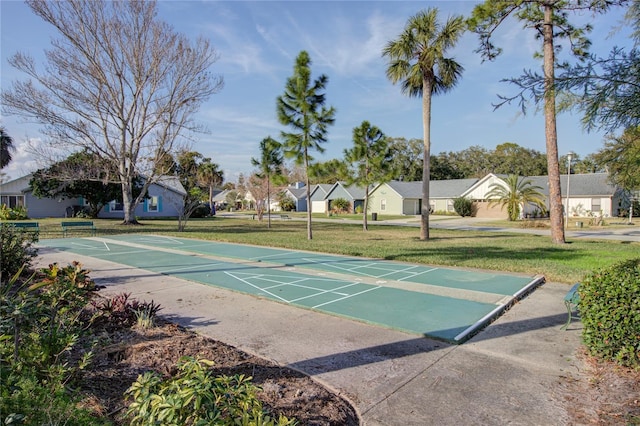 view of community featuring a residential view, a yard, and shuffleboard