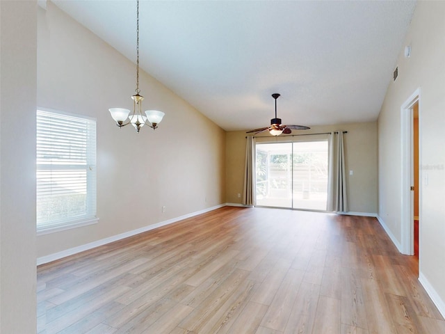 unfurnished room featuring high vaulted ceiling, light wood-style flooring, baseboards, and ceiling fan with notable chandelier