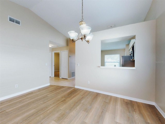 unfurnished room featuring light wood-style floors, lofted ceiling, visible vents, and a notable chandelier