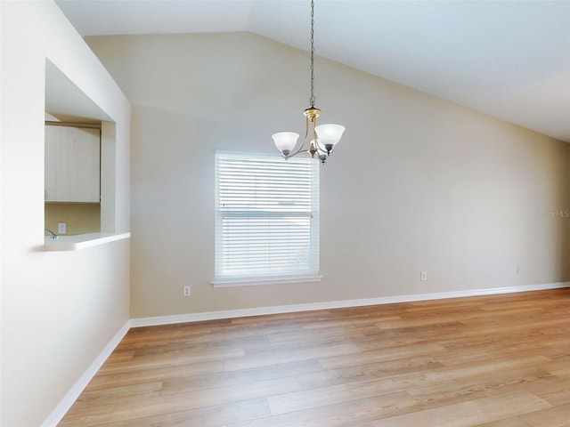 empty room featuring lofted ceiling, light wood finished floors, baseboards, and an inviting chandelier