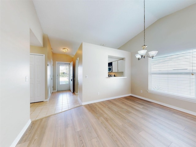 entrance foyer featuring lofted ceiling, light wood finished floors, a chandelier, and baseboards