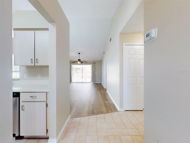 hall featuring light tile patterned floors and baseboards