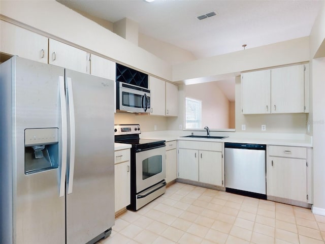 kitchen featuring stainless steel appliances, light countertops, a sink, and visible vents