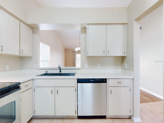 kitchen featuring stainless steel appliances, light countertops, visible vents, vaulted ceiling, and a sink