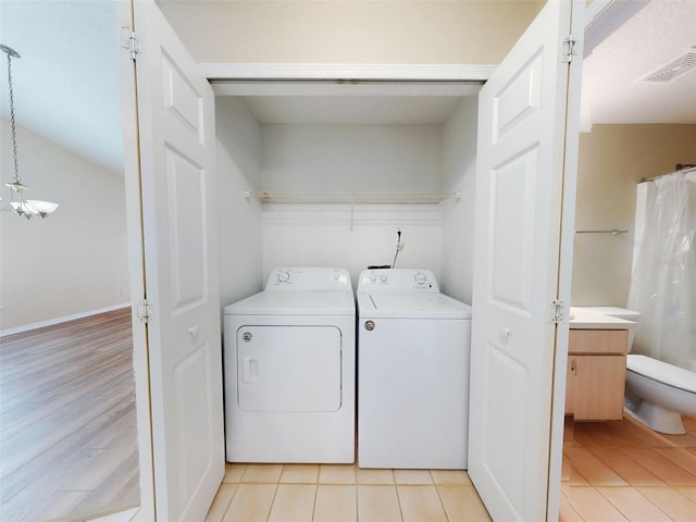 washroom featuring laundry area, light tile patterned flooring, visible vents, and independent washer and dryer