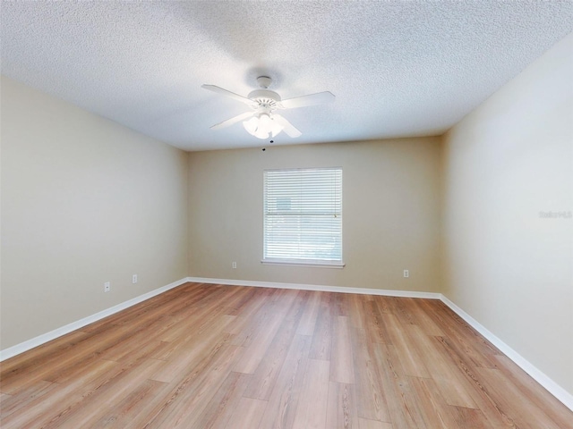 empty room with light wood-style floors, ceiling fan, a textured ceiling, and baseboards