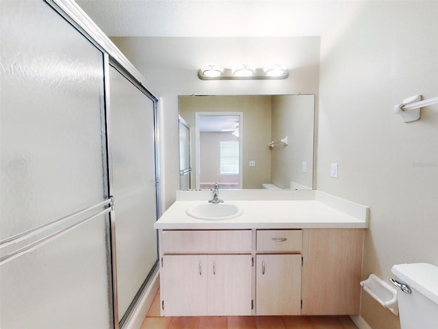bathroom featuring toilet, a shower with door, and vanity