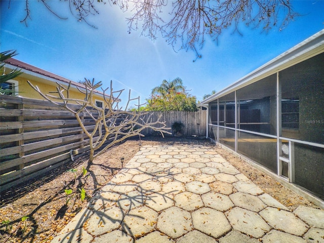 view of patio / terrace featuring a fenced backyard and a sunroom