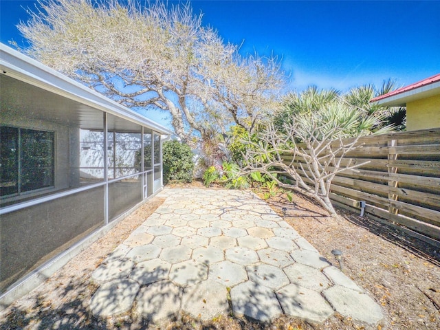 view of patio featuring a sunroom and fence