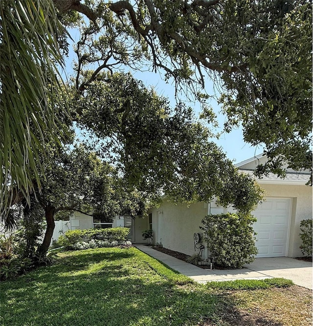 3827 Schoolway Ave, New Smyrna Beach, FL 32169 - view of side of property featuring stucco siding, a yard, driveway, and a garage