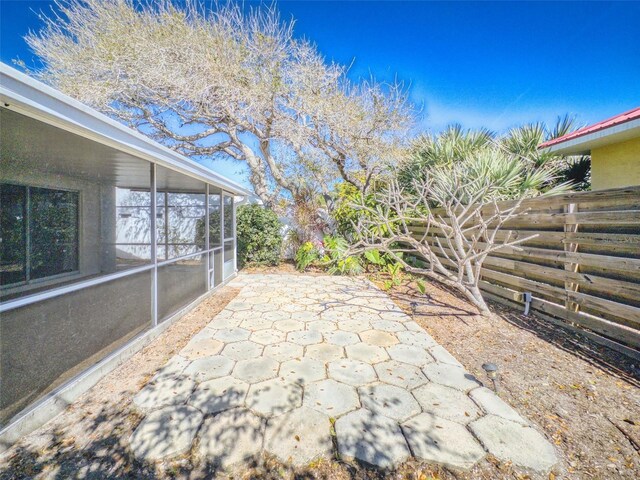 3827 Schoolway Ave, New Smyrna Beach, FL 32169 - view of patio featuring a sunroom and fence