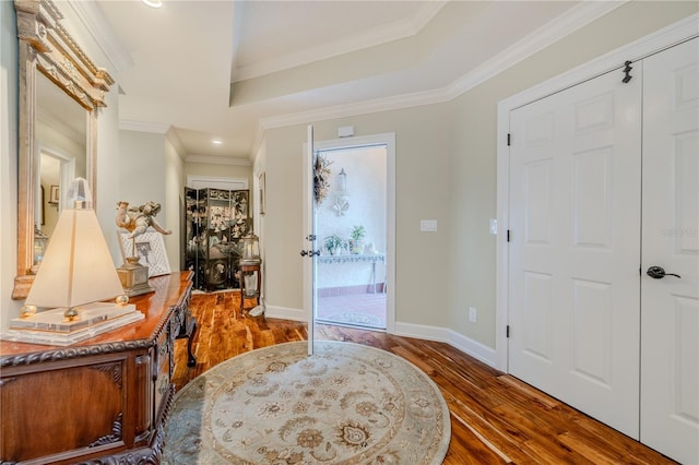 entrance foyer featuring ornamental molding, wood finished floors, and baseboards