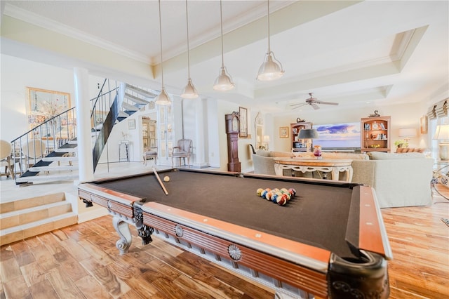 rec room with a tray ceiling, ornamental molding, ceiling fan, wood finished floors, and billiards