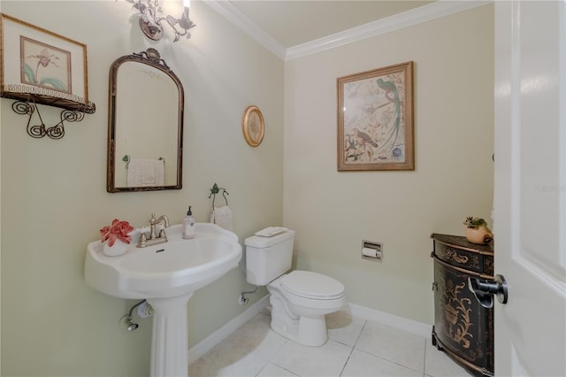 half bathroom featuring ornamental molding, tile patterned flooring, toilet, and baseboards