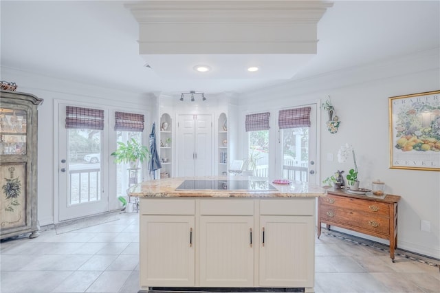 kitchen featuring light stone counters, ornamental molding, and black electric cooktop