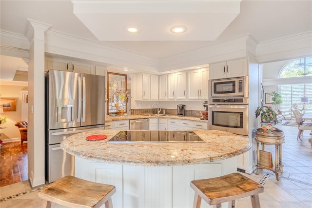 kitchen with appliances with stainless steel finishes, ornamental molding, and a kitchen island