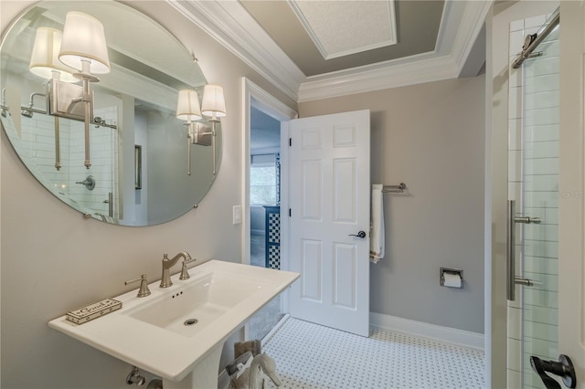 full bath featuring baseboards, a tile shower, a sink, and crown molding