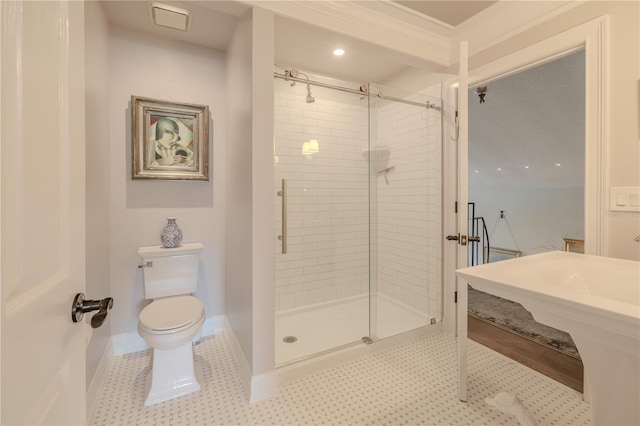 bathroom with tile patterned flooring, baseboards, a shower stall, and toilet