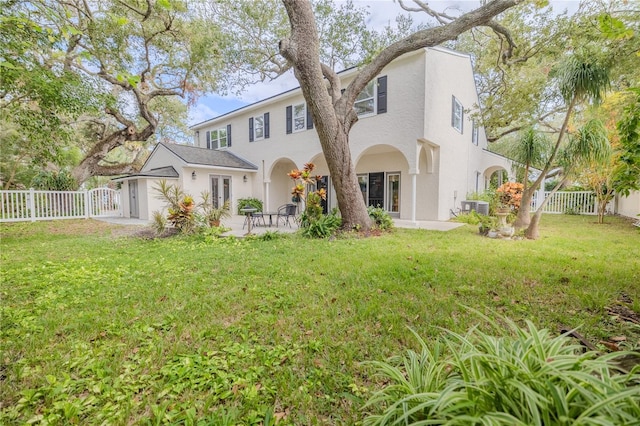 back of house with a patio, a fenced backyard, a lawn, a gate, and stucco siding